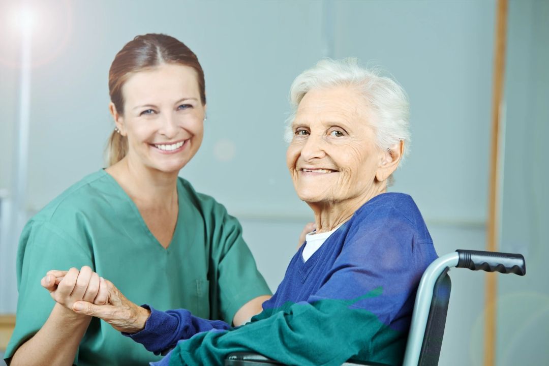 Krankenschwester, die einer älteren Person hilft 