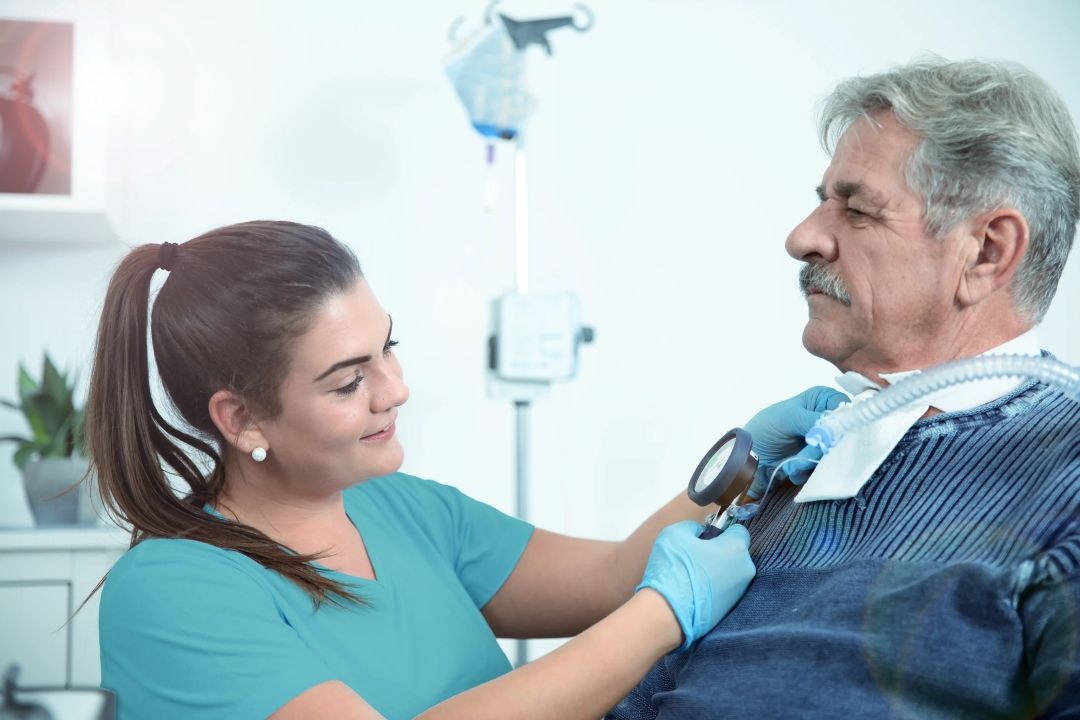 Krankenschwester, die einer älteren Person hilft 